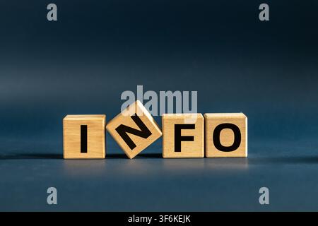 Information and communication concept with wooden blocks spelling INFO on navy blue background. Business data analysis, support desk and message backg Stock Photo