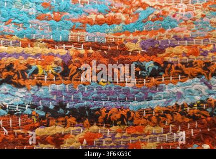 Colorful handwoven rag rug texture with detailed vibrant thread patterns Stock Photo