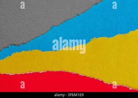 Torn paper layers in gray, blue, yellow, and red create horizontal bands with rough fiber edges. Concept of collage, paper texture for design, copy Stock Photo