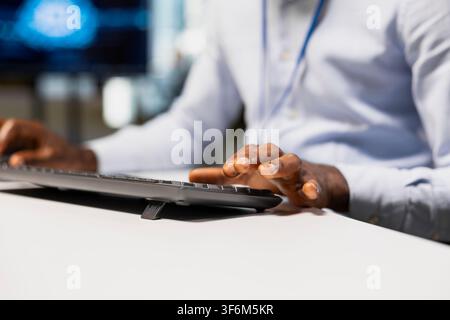 Close up of technician writing code snippets in modern office, adjusting program configurations. Tech company IT specialist running diagnostic tools on PC, monitoring API cloud services Stock Photo