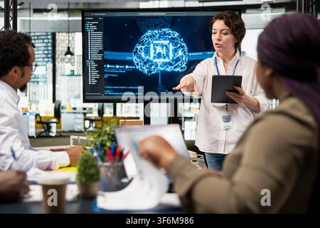 Manager presenting implementation of AI driven solutions to increase productivity in business sector. Executive discussing technology roadmap for software development in startup office Stock Photo