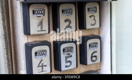 Close up of numbered key lock boxes with combination codes mounted on a wall. Secure key storage, property access, rental management and security conc Stock Photo