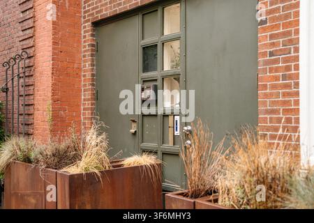 Modern Green Door Entrance On Brick Building Facade Stock Photo
