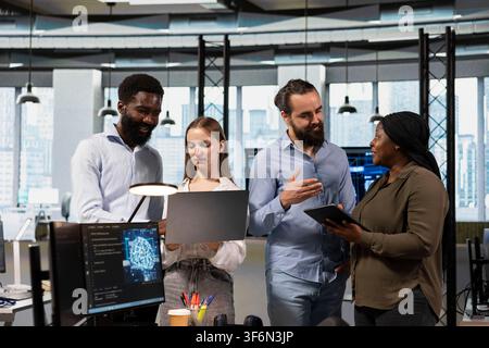 Team of programmers in office using AI automation scripts to reduce repetitive coding tasks in tech office. Teamworking IT specialists using artificial intelligence technology in startup workspace Stock Photo