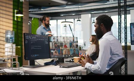 Tech startup office team collaborating via videocall, doing brainstorming on backup solutions to protect against data loss. Remote developers doing AI coding during online teleconference, camera A Stock Photo