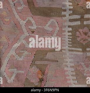 Handwoven kilim rug presenting a detailed close-up of its surface, featuring complex geometric patterns, abstract shapes, and a rich textile texture i Stock Photo