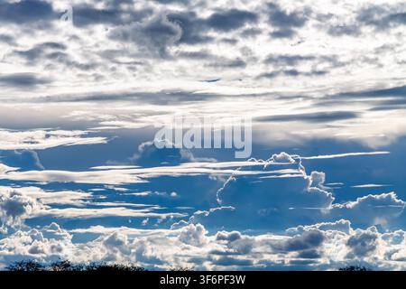 A blue, white and silver cloud scape of mixed cirrus and cumulus formations fills the skies above Ntabazinduna, Zimbabwe Stock Photo
