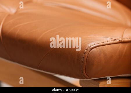 Close up of a tan leather cushion with visible stitching and texture, furniture detail and upholstery material, the warm brown tones and visible seams Stock Photo