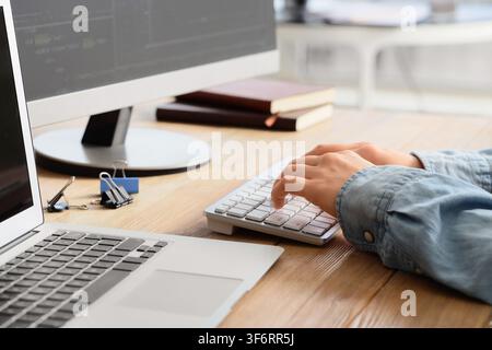 Female programmers hands testing code on computer in office, closeup Stock Photo