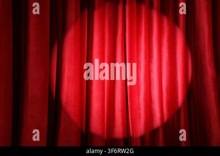 Shining spotlight on red curtain Stock Photo