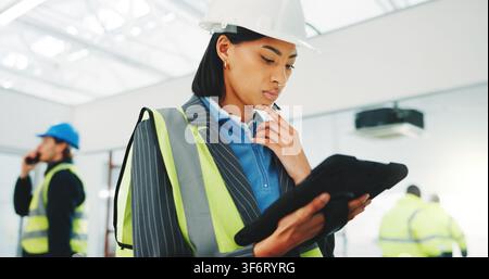 Architect, woman and thinking at construction site with tablet, research or check project timeline. Person, reading and PPE with tech for problem Stock Photo