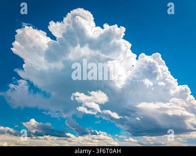 Towering cumulus clouds rising against a vivid blue sky on a bright summer day Stock Photo