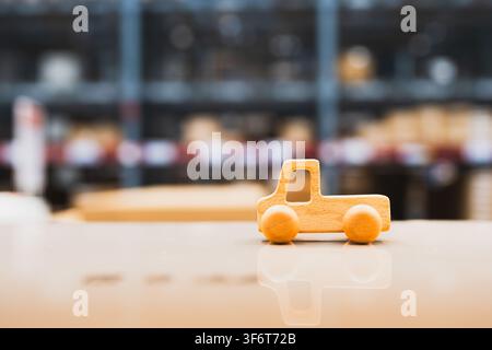 Wooden toy truck symbolizing delivery and logistics service in warehouse environment. Concept of transportation, cargo distribution, and shipping. Stock Photo
