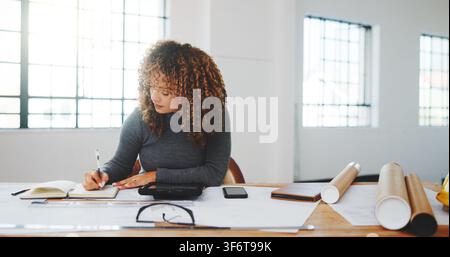 Architect, writing and woman in office with notebook, design plan and draft of renovation project. Development, review and engineer with notes Stock Photo