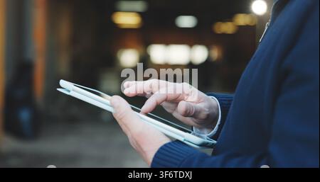 Construction, review or hands with tablet, task instruction or inspection report on building site. Bokeh, man or engineer outdoor with tech, project Stock Photo