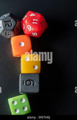 Strategic board game concept featuring polyhedral and standard dice on a dark surface Stock Photo