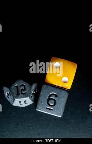 Strategic gaming concept featuring colorful dice isolated on a dark background Stock Photo