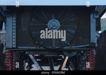 Front close up shot of a large black electric cooling fan attached to an engine radiator on an off road race car frame. Mechanical detail showing radi Stock Photo