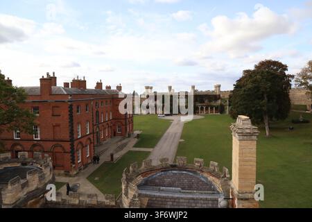 Elevated view of Lincoln Castle grounds featuring the red-brick Victorian Prison building and the distant Gothic Revival Crown Court, UK. Stock Photo