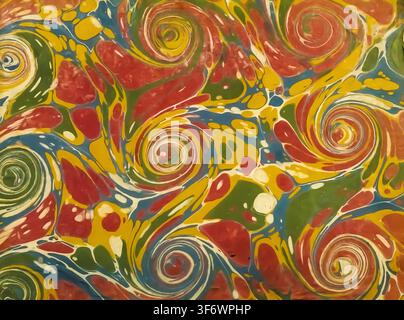 Ebru paper displaying a swirling, colorful abstract pattern of red, yellow, green, and blue paints, creating a visually dynamic and ancient artistic background Stock Photo