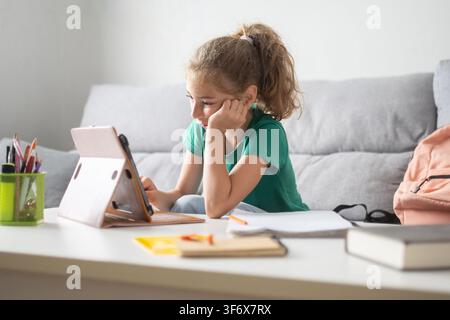 Schoolgirl studying with digital tablet at home Stock Photo