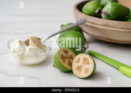 Fresh feijoa fruit sliced open with creamy yogurt Stock Photo