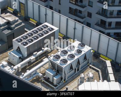 Aerial view of industrial cooling units on a rooftop, likely part of an AI data center, with modern building architecture in Krakow, Lesser Poland Voi Stock Photo