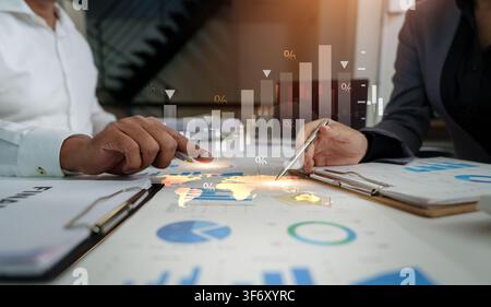 Corporate team analyzing global market data and financial charts on office desk Stock Photo