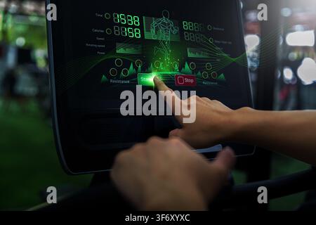 Cropped hand pressing start button on treadmill console for fitness workout Stock Photo