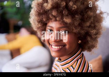 Cheerful portrait of an African young woman looking at camera smiling. Stock Photo
