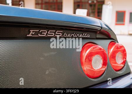 Kempttal, Switzerland, June 5, 2026. Close up shot of the rear badge reading F355 berlinetta, rear grill, and iconic round tail lights on a classic bl Stock Photo
