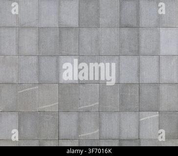 External wall covering of rectangular porcelain stoneware tiles with a natural stone effect, arranged in a straight vertical grid pattern. Full frame, Stock Photo