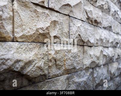 Close-up of sandstone wall featuring textured stone block being lit by soft morning sunlightClose-up of sandstone wall featuring textured stone block Stock Photo