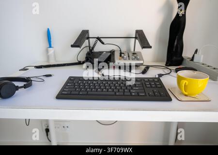 coffee cup on ergonomic office desk with keyboard headphone and modern workstation setup Stock Photo