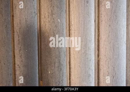 Full frame background texture of weathered metallic grooved slats with vertical parallel lines and aged surface. Stock Photo