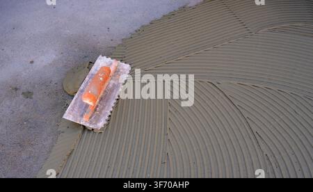 Gray Cement Adhesive Prepared for Ceramic Floor Installation Stock Photo