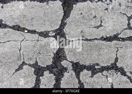 Abstract grunge texture of severe cracking on white painted road marking, pedestrian zebra crossing background Stock Photo