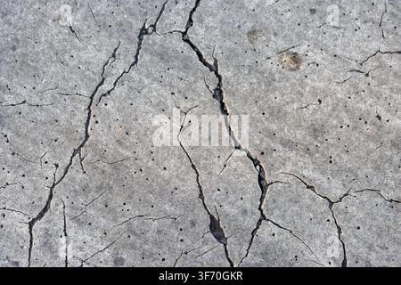 Abstract grunge texture of severe cracking on white painted road marking, pedestrian zebra crossing background Stock Photo