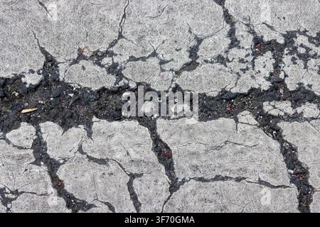 Abstract grunge texture of severe cracking on white painted road marking, pedestrian zebra crossing background Stock Photo