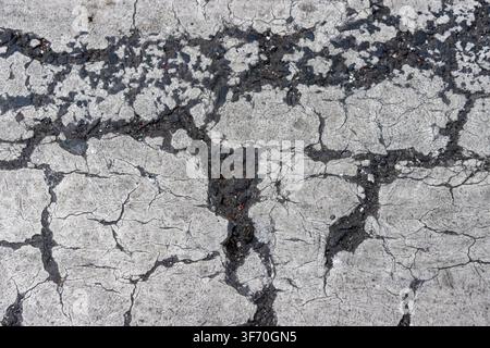 Abstract grunge texture of severe cracking on white painted road marking, pedestrian zebra crossing background Stock Photo