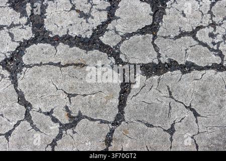 Abstract grunge texture of severe cracking on white painted road marking, pedestrian zebra crossing background Stock Photo