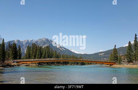 Nancy Pauw Bridge in Banff National Park, Canada. The pedestrian bridge across the Bow River offers panoramic views of the surrounding Rocky Mountains. Stock Photo