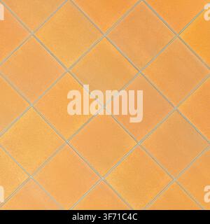 A seamless texture of orange terracotta square floor tiles arranged diagonally. Stock Photo