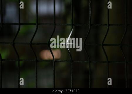 Metal mesh fence caught in low light at the zoo in Ciego de Avila, Cuba - July 26, 2026 Stock Photo