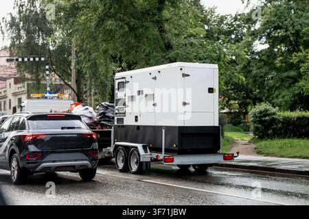 Mobile diesel generator unit housed in soundproof acoustic enclosure loaded on dual axle utility trailer for emergency power deployment Stock Photo