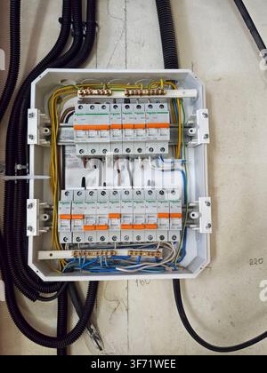 Kirov, Russia - February 26, 2026: A circuit breaker panel is shown mounted on a wall with wires connected to multiple switches for managing home elec Stock Photo