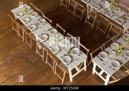 Elegant wedding banquet setup in a rustic, restored timber-frame barn, prepared for guests to celebrate the couple’s nuptials. Stock Photo