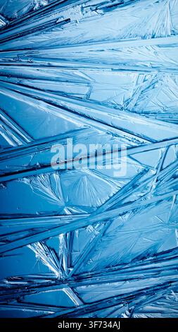 Ice frozen in intricate patterns of delicate crystals with brilliant contrasts of deep blues. Real unique patterned crystal formations. Sparkling wind Stock Photo