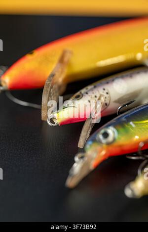 Artificial fishing bait arranged on dark surface The Concept of sports equipment Stock Photo