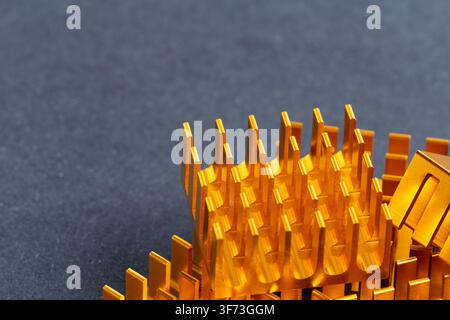 Golden metallic fins stand sharp against a dark surface. Structured design suggests high-tech engineering precision. Clean lines reflect industrial cr Stock Photo
